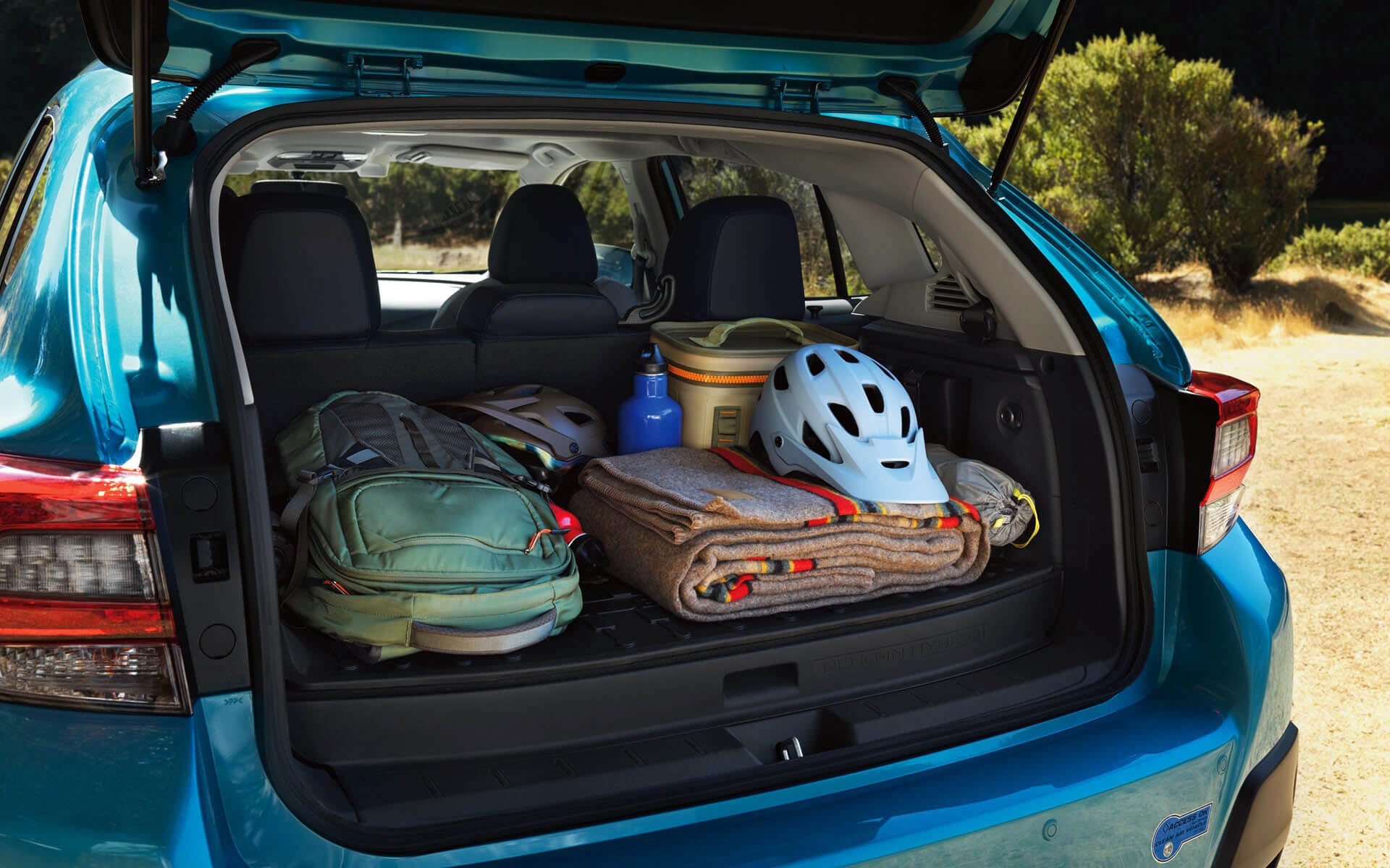 A backpack, blanket, and bike helmet in the rear cargo area of a Crosstrek Hybrid | Paul Moak Subaru in Jackson MS