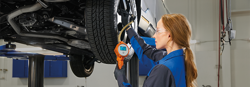 A Subaru technician checking tire pressure. | Paul Moak Subaru in Jackson MS
