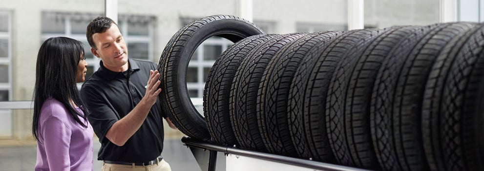 Subaru service representative showing customer a tire. | Paul Moak Subaru in Jackson MS